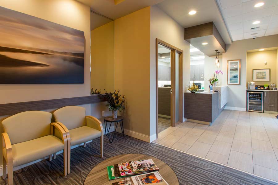 Lobby and seating area near entryway an reception desk at Karl Hoffman Dentistry in Lacey, WA