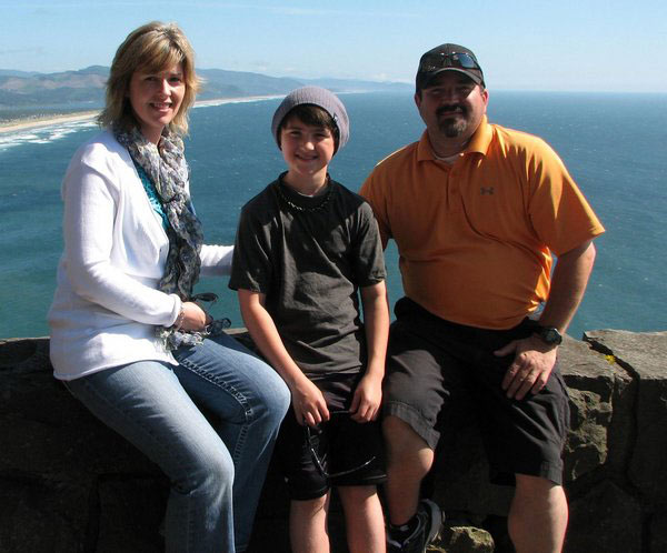 Family of three sitting in front of beach, patients at Karl Hoffman Dentistry in Lacey, WA