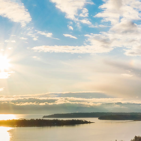 Sunshine over cloudy Puget Sound islands.