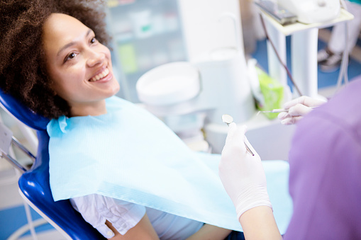 Smiling woman in dental chair looking up at dental assistant at Karl Hoffman Dentistry in Lacey, WA