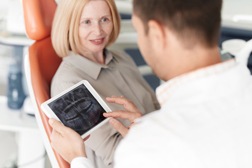 Older woman in dental chair speaking with doctor at Karl Hoffman Dentistry in Lacey, WA